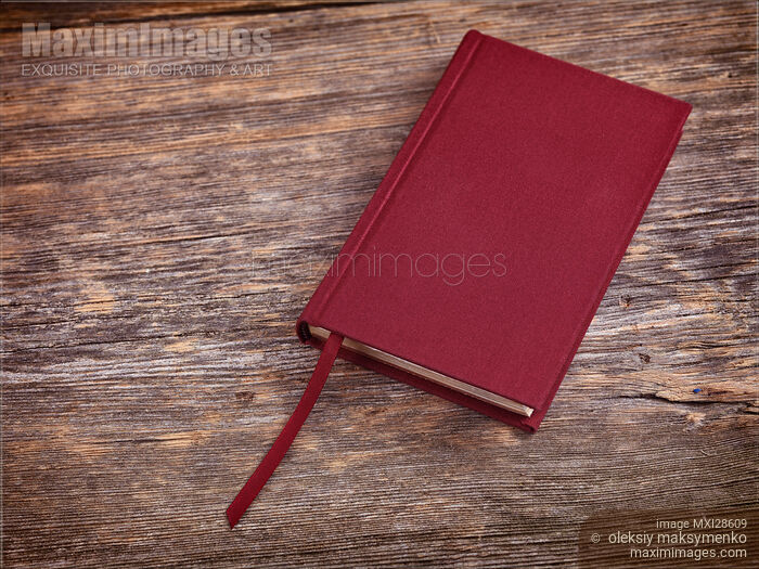 Stock photo of Red hardcover book on wood background Buy commercial use license at MaximImages