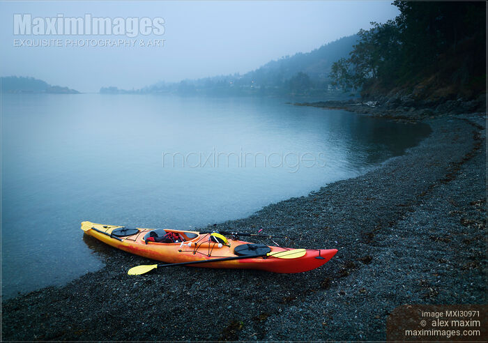 Red kayak on the shore of Salish sea in yearly misty morning at Vancouver Island Stock photo of Red kayak on the shore of Salish sea in yearly misty morning at Vancouver Island Buy commercial use license at MaximImages