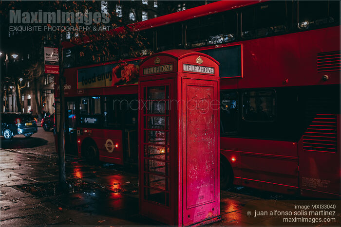 Red telephone booth and city bus on night street after rain in London England Stock photo of Red telephone booth and city bus on night street after rain in London England Buy commercial use license at MaximImages