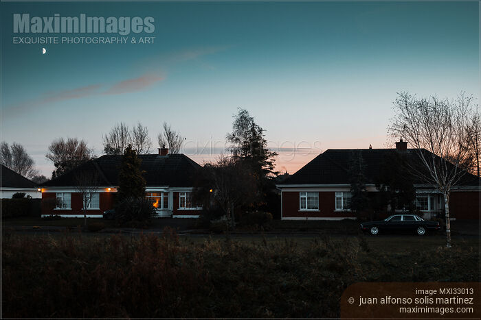 Stock photo of Residential houses on a street in dramatic twilight suburban town scenery Ireland Buy commercial use license at MaximImages