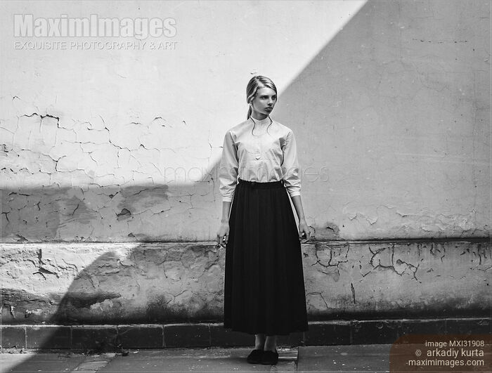 Retro black and white portrait of a young girl dressed in peasant clothing standing against a wall Stock photo of Retro black and white portrait of a young girl dressed in peasant clothing standing against a wall Buy commercial use license at MaximImages