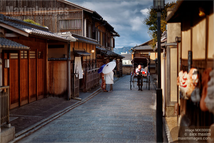 Rickshaw passing a Japanese couple wearing traditional kimono walking down an old street in Kyoto Stock photo of Rickshaw passing a Japanese couple wearing traditional kimono walking down an old street in Kyoto Buy commercial use license at MaximImages