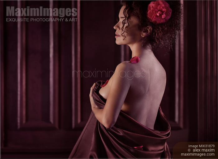 Romantic boudoir portrait of woman with flower in hair wrapping in bed sheets Stock photo of Romantic boudoir portrait of woman with flower in hair wrapping in bed sheets Buy commercial use license at MaximImages