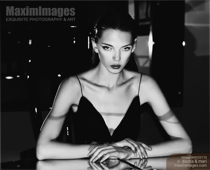 Seductive woman in sexy black dress sitting at restaurant table, edgy fashion femme fatale portrait Stock photo of Seductive woman in sexy black dress sitting at restaurant table, edgy fashion femme fatale portrait Buy commercial use license at MaximImages