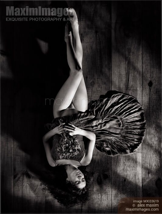 Sensual black and white art nude portrait of woman in dress with bare legs lying half naked on the floor with flowers Stock photo of Sensual black and white art nude portrait of woman in dress with bare legs lying half naked on the floor with flowers Buy commercial use license at MaximImages