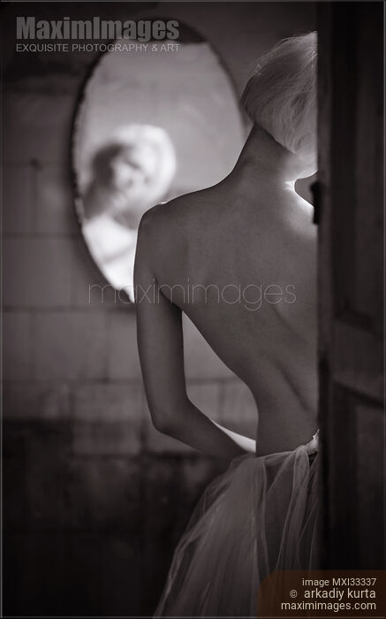 Sensual black and white portrait of a sexy woman standing by the mirror, rear view of her back Stock photo of Sensual black and white portrait of a sexy woman standing by the mirror, rear view of her back Buy commercial use license at MaximImages