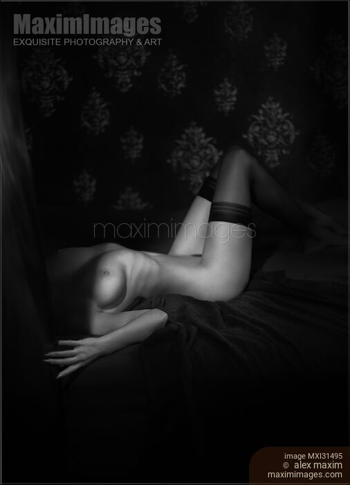 Stock photo of Sensual body of a woman lying in bed naked wearing only stockings Black and white art nude Buy commercial use license at MaximImages