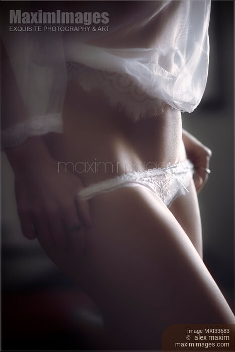 Sensual boudoir closeup of a sexy woman in underwear undressing taking off her white lace panties Stock photo of Sensual boudoir closeup of a sexy woman in underwear undressing taking off her white lace panties Buy commercial use license at MaximImages