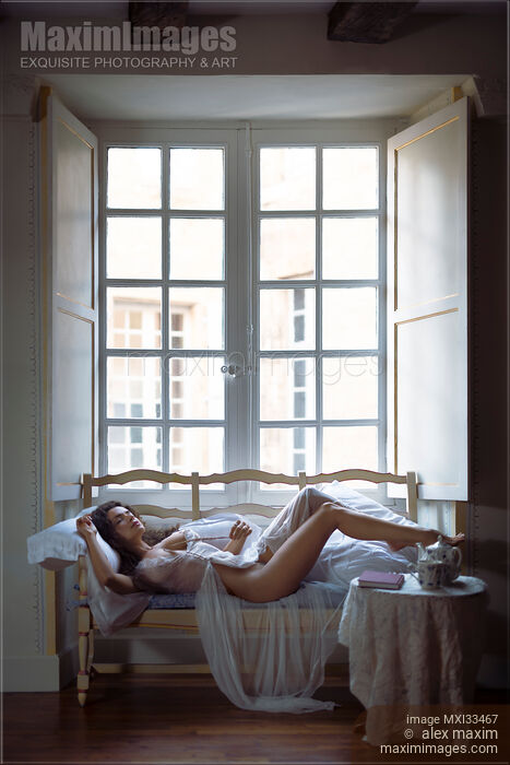 Sensual boudoir portrait of a beautiful half naked woman in sheer white nightwear lying on vintage sofa Stock photo of Sensual boudoir portrait of a beautiful half naked woman in sheer white nightwear lying on vintage sofa Buy commercial use license at MaximImages