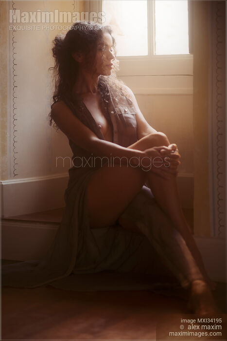 Sensual boudoir portrait of a sexy young woman in unbuttoned sheer dress sitting dreamily on the floor by a window Stock photo of Sensual boudoir portrait of a sexy young woman in unbuttoned sheer dress sitting dreamily on the floor by a window Buy commercial use license at MaximImages