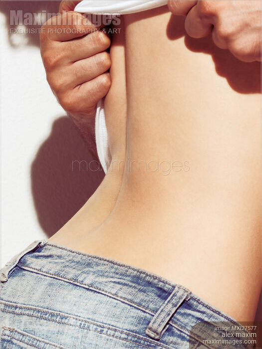 Stock photo of Sensual closeup of man taking off woman shirt Buy commercial use license at MaximImages