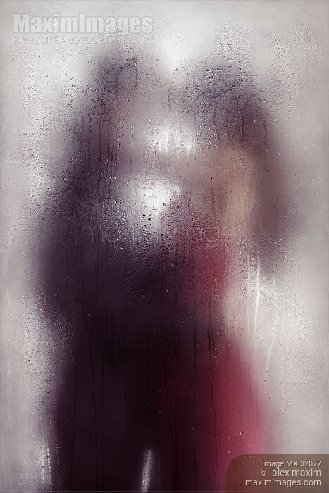 Sensual couple kissing standing behind wet glass in an embrace Dreamy abstract fine art concept Stock photo of Sensual couple kissing standing behind wet glass in an embrace Dreamy abstract fine art concept Buy commercial use license at MaximImages