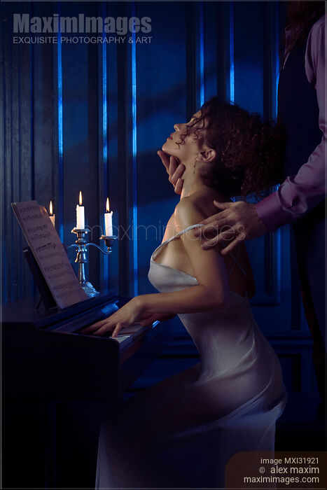 Sensual couple romantic portrait man caressing neck of a woman playing the piano in candle light Stock photo of Sensual couple romantic portrait man caressing neck of a woman playing the piano in candle light Buy commercial use license at MaximImages