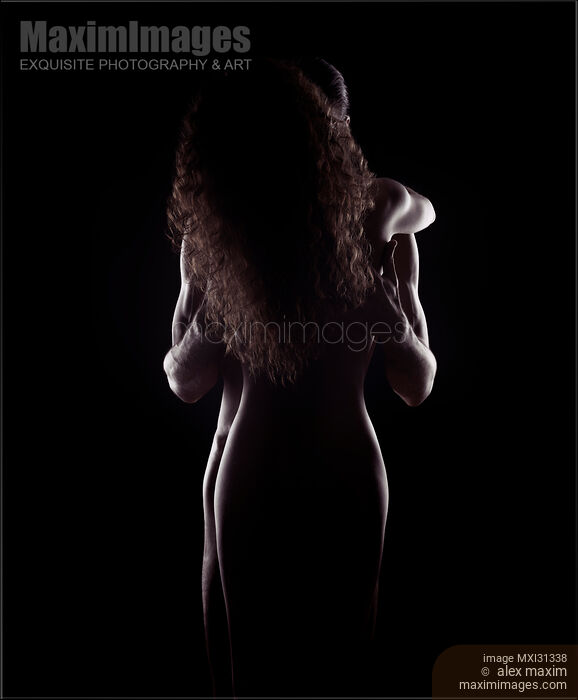 Stock photo of Sensual nude couple standing in an embrace naked bodies silhouette on black background Buy commercial use license at MaximImages