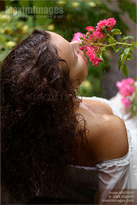 Sensual portrait of a woman smelling roses in a garden in the rain Stock photo of Sensual portrait of a woman smelling roses in a garden in the rain Buy commercial use license at MaximImages