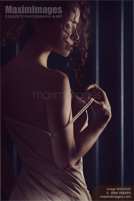 Sensual portrait of a woman taking off a shoulder strap of her camisole night gown Stock photo of Sensual portrait of a woman taking off a shoulder strap of her camisole night gown Buy commercial use license at MaximImages