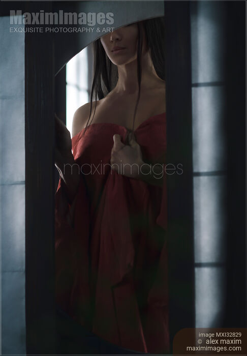 Sensual portrait of an Asian woman in undone red kimono standing by an open shoji window of a Japanese house Stock photo of Sensual portrait of an Asian woman in undone red kimono standing by an open shoji window of a Japanese house Buy commercial use license at MaximImages