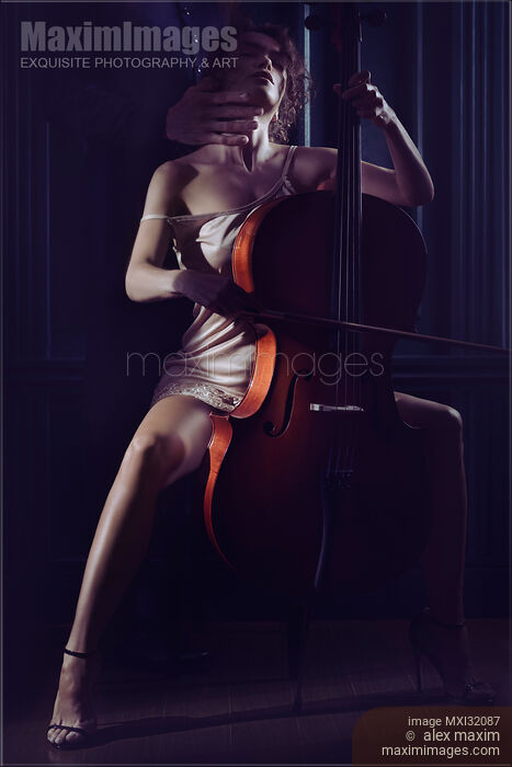 Stock photo of Sensual romantic concept of a man caressing neck of a sexy woman playing a cello in dim night light Buy commercial use license at MaximImages