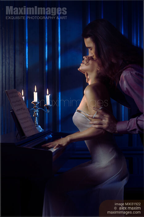 Sensual romantic couple man with long hair caressing woman at a piano reaching to kiss Stock photo of Sensual romantic couple man with long hair caressing woman at a piano reaching to kiss Buy commercial use license at MaximImages
