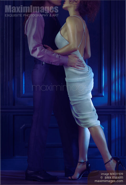Stock photo of Sexy elegant couple kissing in a dance like dynamic portrait in dim night settings Buy commercial use license at MaximImages
