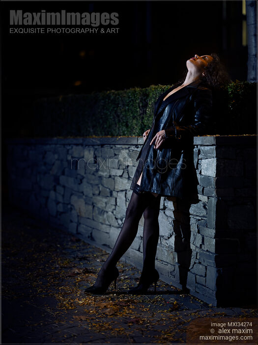Sexy woman dressed in black leather coat and black stockings standing on city street looking at night sky Stock photo of Sexy woman dressed in black leather coat and black stockings standing on city street looking at night sky Buy commercial use license at MaximImages