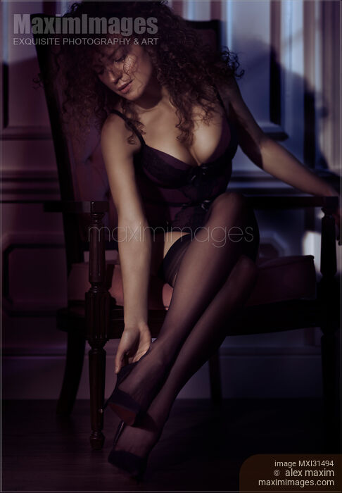 Stock photo of Sexy woman in lingerie and black stockings taking off her high heel shoes Buy commercial use license at MaximImages