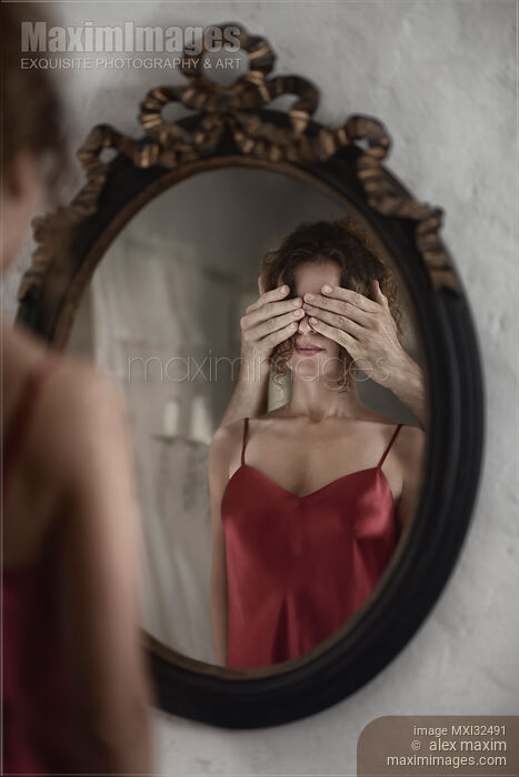 Sexy woman in red nightgown reflecting in a mirror with male hands covering her eyes from behind Stock photo of Sexy woman in red nightgown reflecting in a mirror with male hands covering her eyes from behind Buy commercial use license at MaximImages