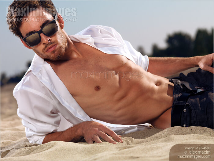 Stock photo of Sexy young man at the beach Buy commercial use license at MaximImages