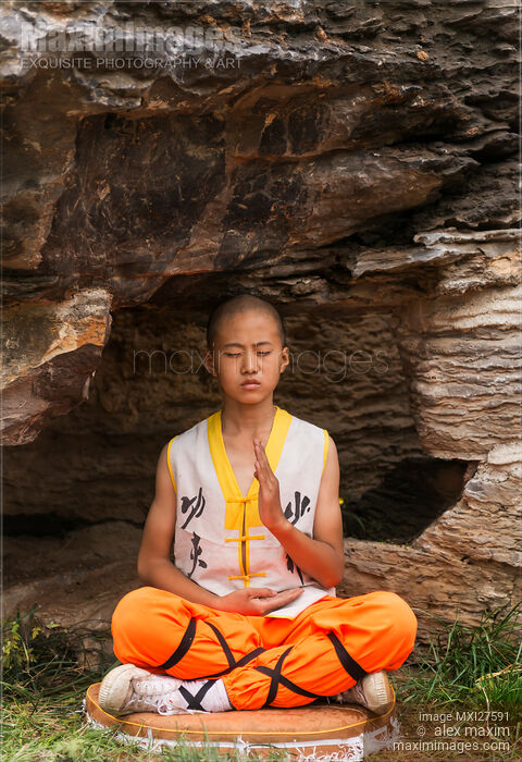 Stock photo of Shaolin martial arts school student meditating under rocks Buy commercial use license at MaximImages