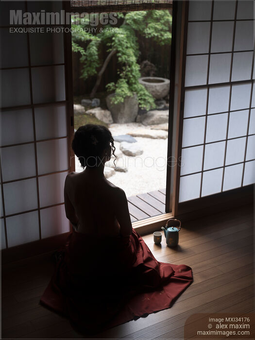 Stock photo of Silhouette of a woman with naked back sitting inside by an open Shoji door looking at Japanese Zen garden Buy commercial use license at MaximImages