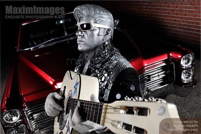 Stock photo of Silver Elvis mime with a guitar and Cadillac Buy commercial use license at MaximImages