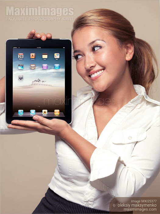 Stock photo of Smiling girl looking at iPad in her hands Buy commercial use license at MaximImages