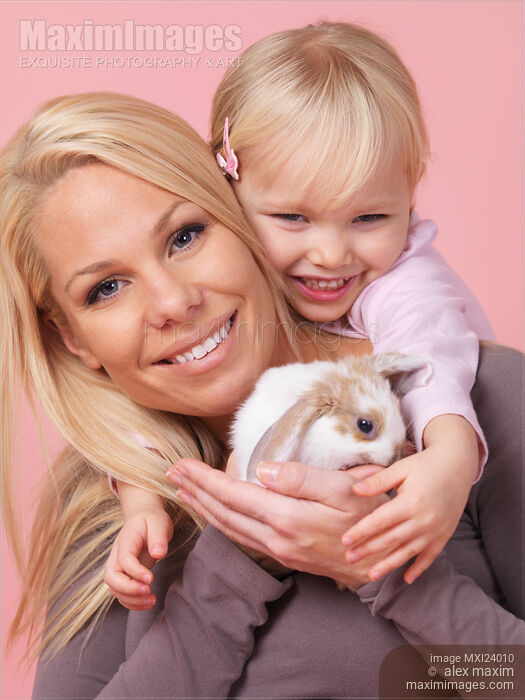 Stock photo of Smiling mother and daughter with a bunny Buy commercial use license at MaximImages