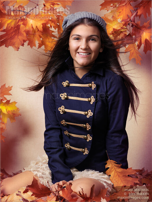 Smiling teenage girl sitting on red autumn leaves Stock photo of Smiling teenage girl sitting on red autumn leaves Buy commercial use license at MaximImages