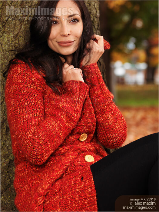 Stock photo of Smiling Woman Cuddling in a Sweater in the Wind Buy commercial use license at MaximImages