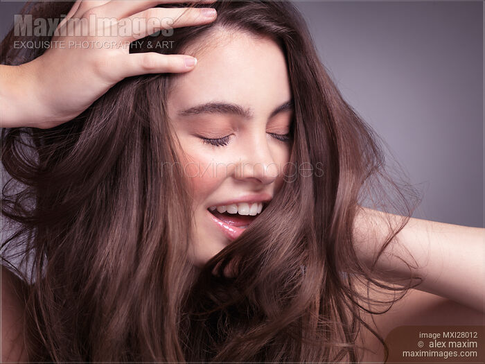 Smiling young woman with long brown hair Stock photo of Smiling young woman with long brown hair Buy commercial use license at MaximImages