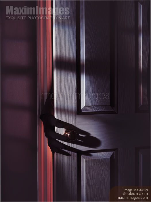 Spooky male hand in a glove reaching for a door handle from behind a door in a dark shadowy room Stock photo of Spooky male hand in a glove reaching for a door handle from behind a door in a dark shadowy room Buy commercial use license at MaximImages