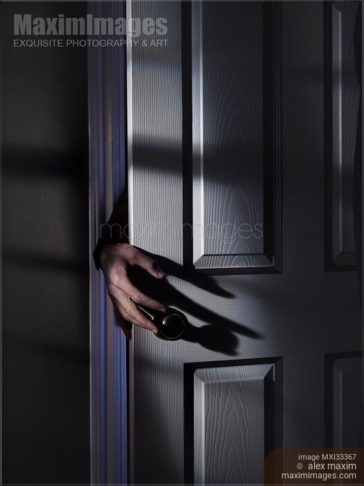 Spooky male hand reaching for a door handle from behind a door in a dark shadowy house room Stock photo of Spooky male hand reaching for a door handle from behind a door in a dark shadowy house room Buy commercial use license at MaximImages