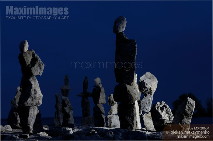 Stock photo of Stone figures over dark night sky Buy commercial use license at MaximImages