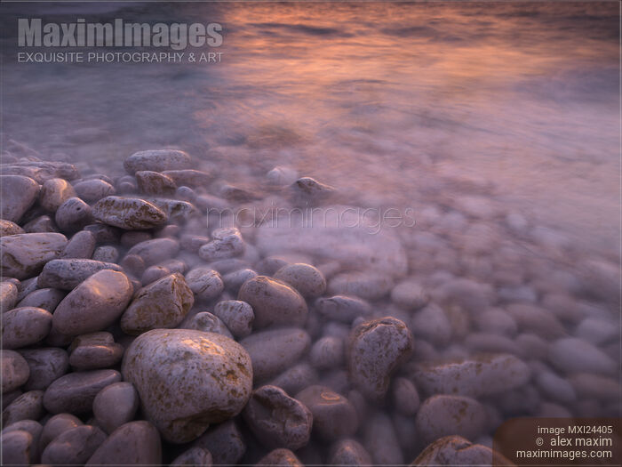 Sunset reflecting in water of a rocky shore Stock photo of Sunset reflecting in water of a rocky shore Buy commercial use license at MaximImages