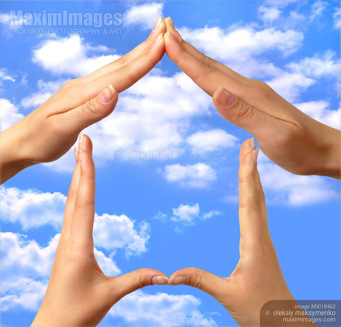 Stock photo of Symbol home made by hands over blue sky Buy commercial use license at MaximImages