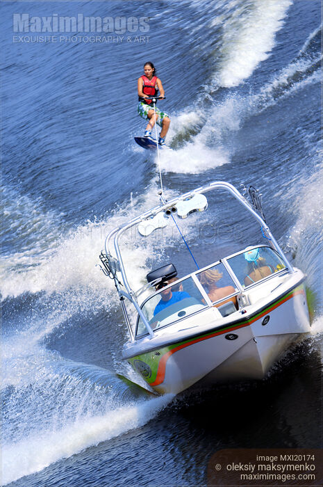 Stock photo of Teenage Girl Riding Wakeboard Behind Motorboat Buy commercial use license at MaximImages