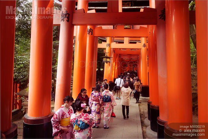 Stock photo of Tourists and women in kimono walking along a long Senbon torii path at Fushimi Inari shrine in Kyoto Japan Buy commercial use license at MaximImages