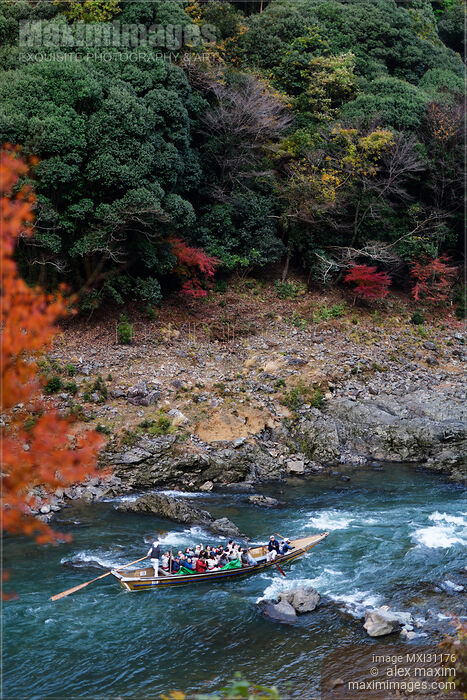 Stock photo of Tourists on Hozugawa river sightseeing cruise boat ride in autumn scenery of Hozukyo Ravine Buy commercial use license at MaximImages