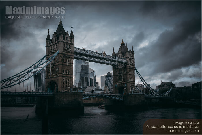 Tower Bridge in London across river Thames Dramatic moody city scenery Stock photo of Tower Bridge in London across river Thames Dramatic moody city scenery Buy commercial use license at MaximImages