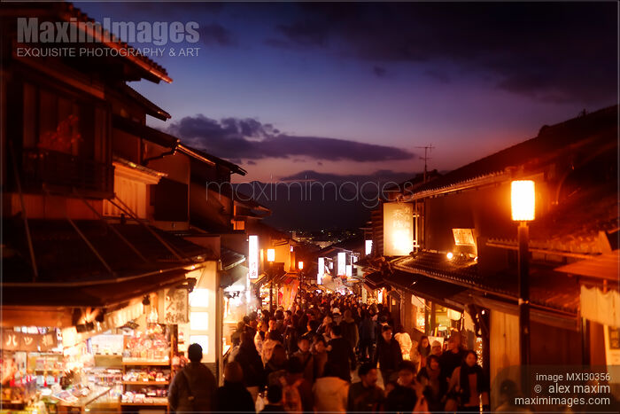 Twilight old Kyoto city scenery at Matsubara dori street in fall with brightly lit shops and street lights Stock photo of Twilight old Kyoto city scenery at Matsubara dori street in fall with brightly lit shops and street lights Buy commercial use license at MaximImages