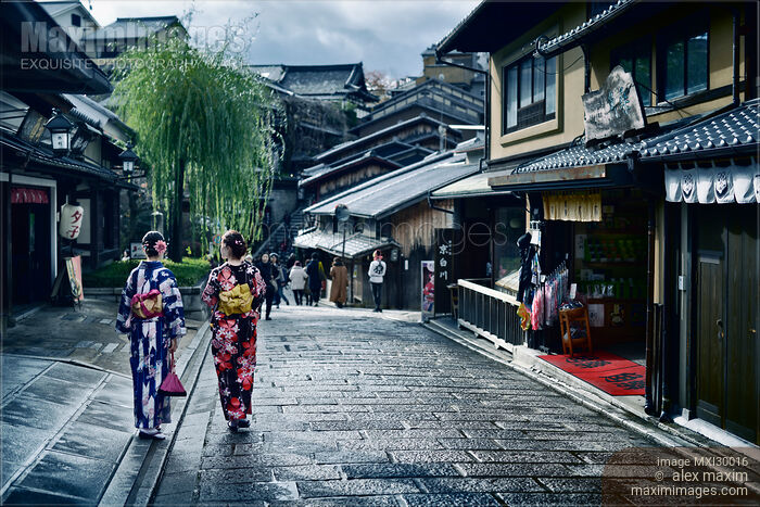Two girls in bright Yukata kimonos with their obi tied in bow walking on street in Kyoto Japan Stock photo of Two girls in bright Yukata kimonos with their obi tied in bow walking on street in Kyoto Japan Buy commercial use license at MaximImages