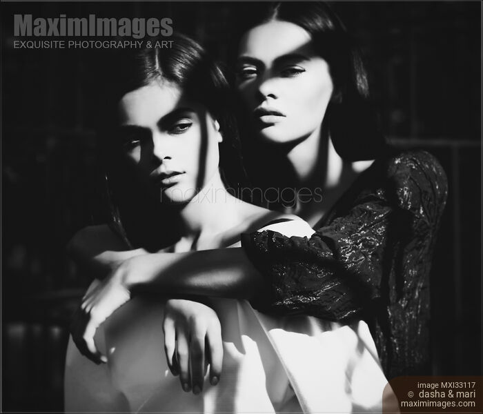 Two ladies together. Woman standing behind another embracing her. Vintage stylized dramatic portrait. Stock photo of Two ladies together. Woman standing behind another embracing her. Vintage stylized dramatic portrait. Buy commercial use license at MaximImages