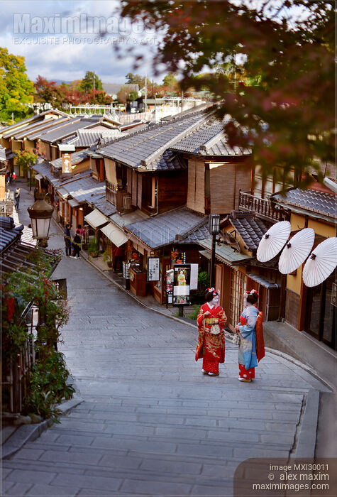 Stock photo of Two Maiko Geisha apprentices in colorful kimono on old street Yasaka dori in Kyoto Japan Buy commercial use license at MaximImages