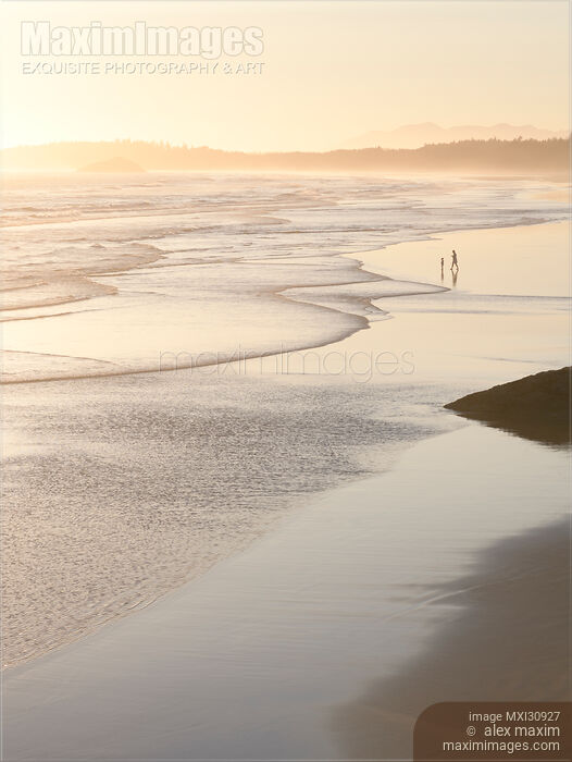 Stock photo of Two people on the ocean beach in sunset at Pacific Rim National Park Tofino Buy commercial use license at MaximImages